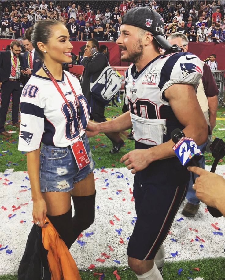 two football players are shaking hands at the end of a game with confetti on the ground