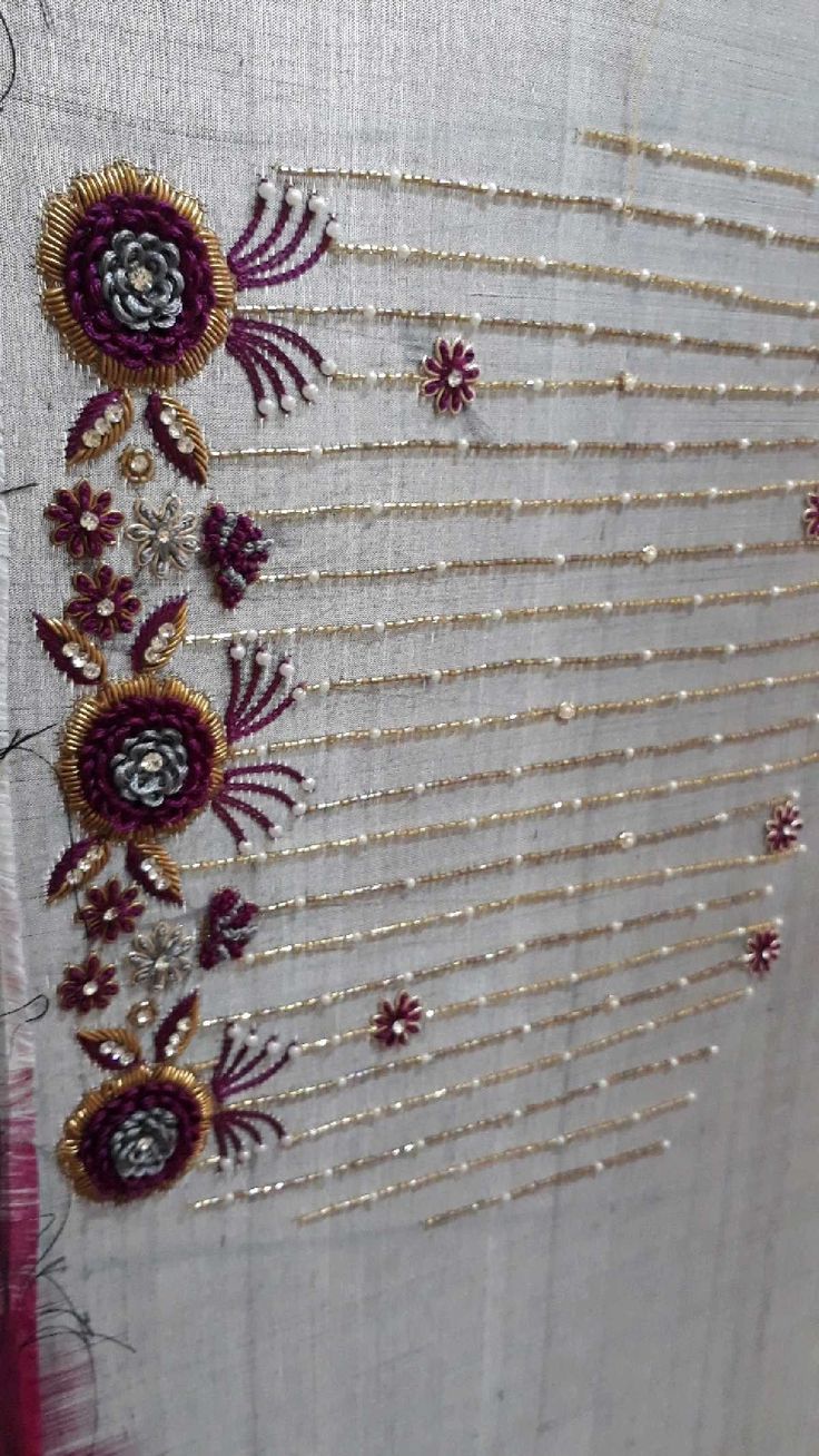 an embroidered piece with beads and flowers on it