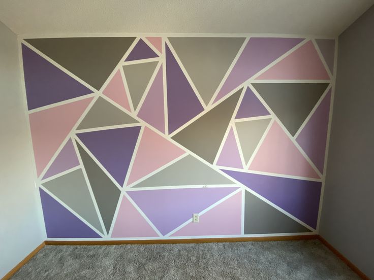 an empty room with pink, grey and white wallpaper