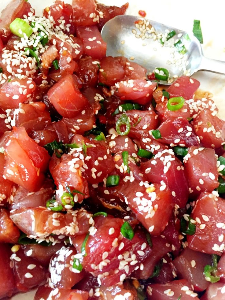 a white plate topped with meat and sesame seeds