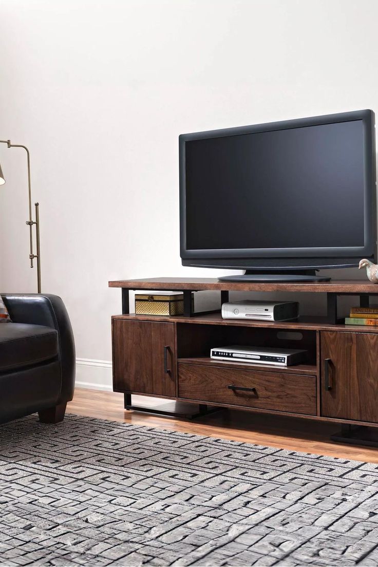 a flat screen tv sitting on top of a wooden entertainment center in a living room