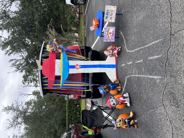 people are sitting at tables on the side of the road, with decorations around them