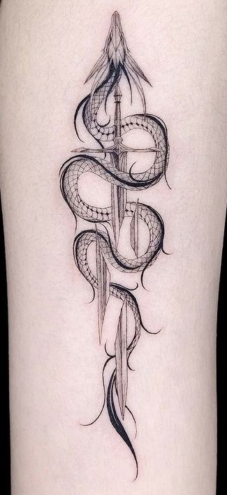 a snake and dagger tattoo on the back of a woman's lower leg,