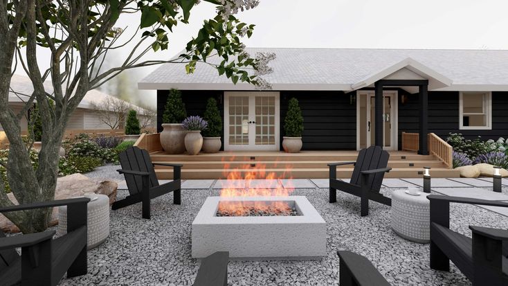 a fire pit sitting in the middle of a gravel covered yard next to a house