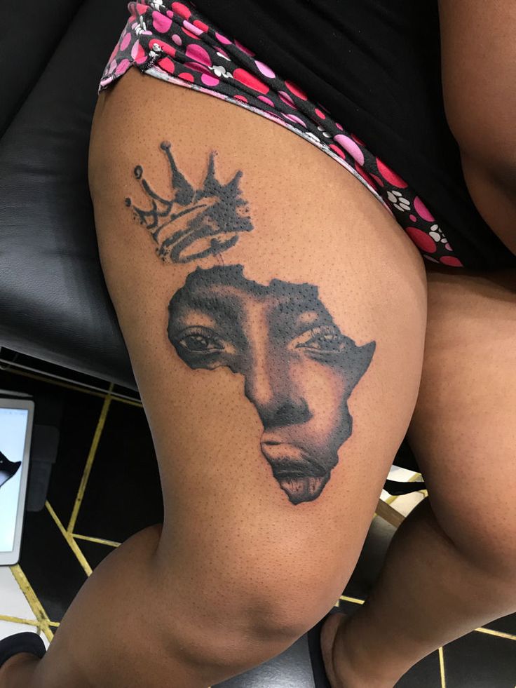 a woman's thigh with a tattoo on the side of her leg and an image of a woman wearing a crown