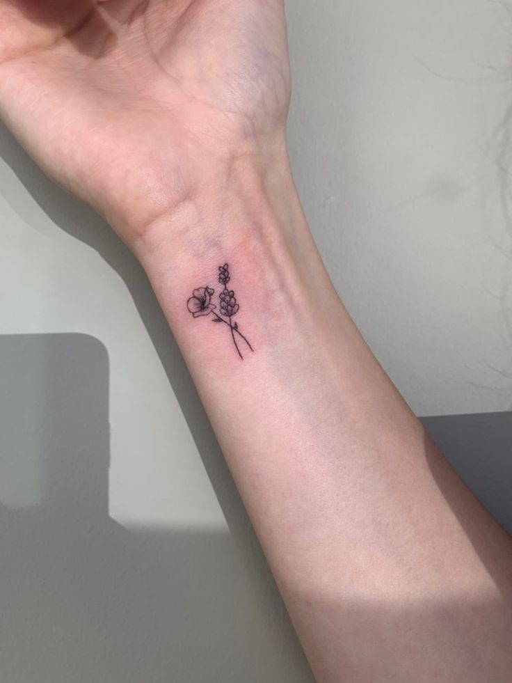 a small flower tattoo on the wrist