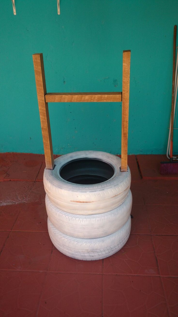 a chair made out of two old tires sitting on top of a red tile floor