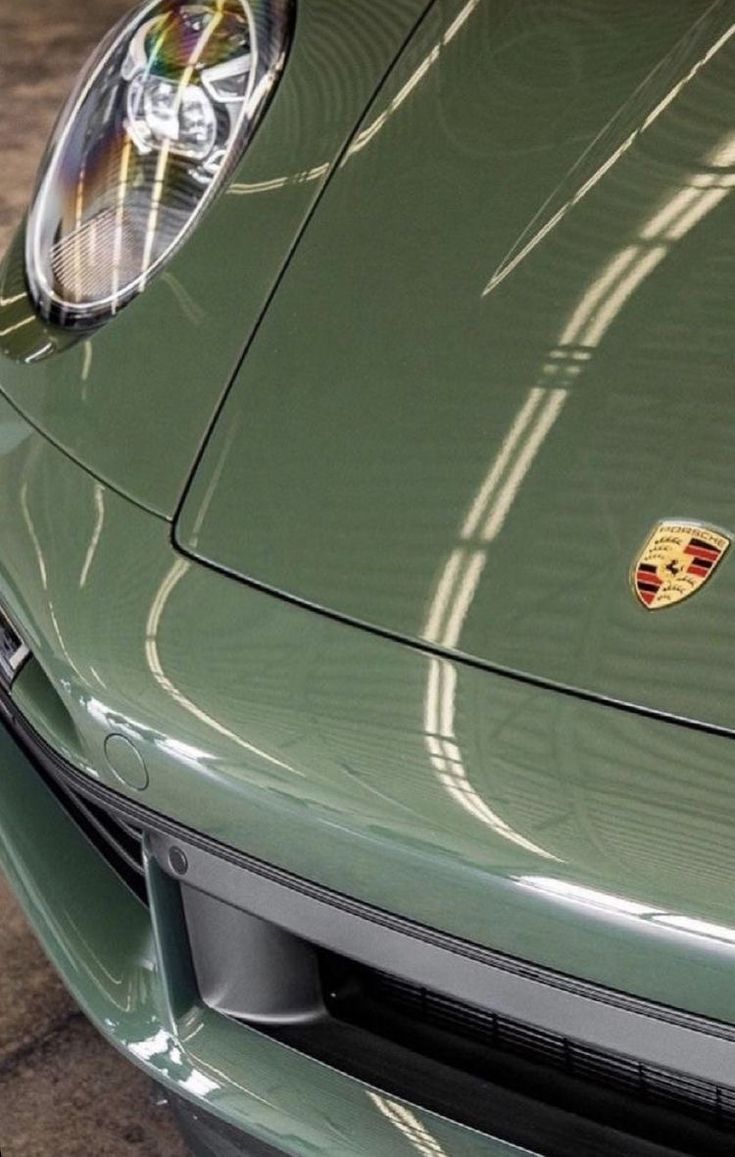 the front end of a green porsche sports car