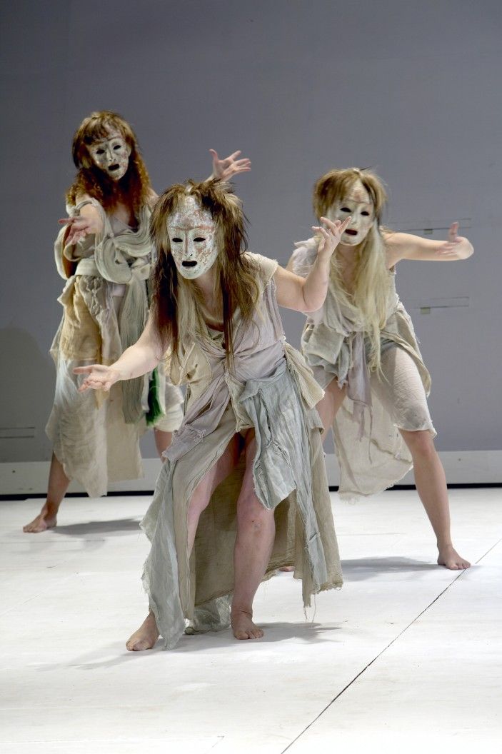 three women with painted faces are dancing on stage