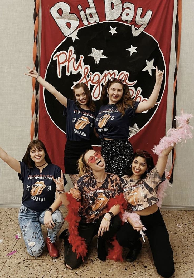 some people are posing for a photo in front of a big day sign with their hands up