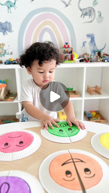 a little boy that is sitting at a table with paper plates in front of him