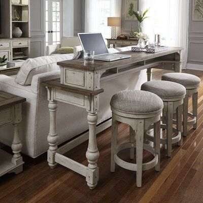 a living room filled with furniture and a laptop computer on top of a wooden table