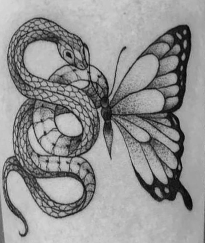 a black and white photo of a butterfly with a snake on it's back