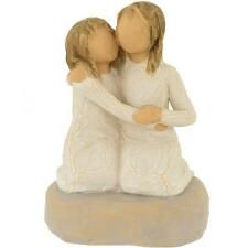 a figurine of two women hugging each other with their arms around one another