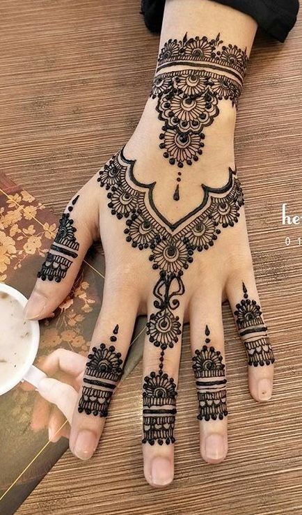 a woman's hand with henna tattoos on it