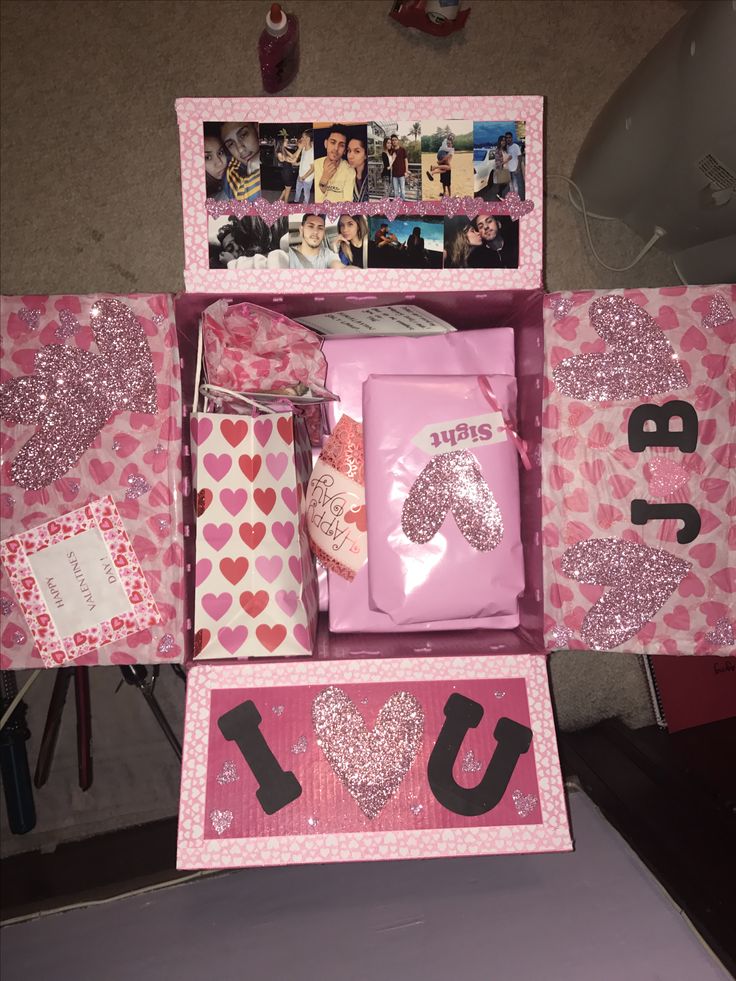 a pink box filled with lots of valentine's day items and pictures on it