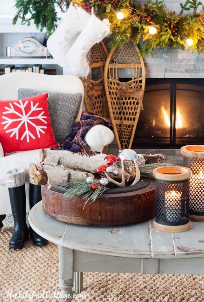 a living room filled with furniture and a fire place covered in christmas decorations on top of a coffee table