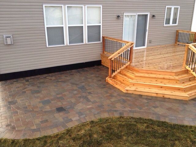 a wooden deck with steps and railings next to a house