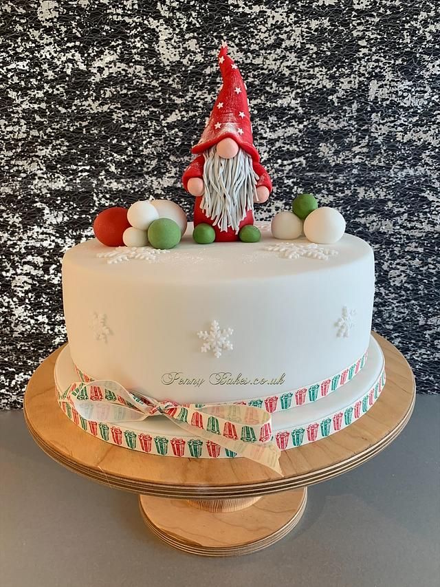 a white cake decorated with an image of a gnome and candy canes on top