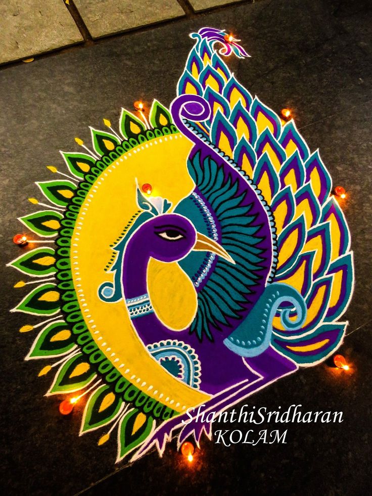 colorful peacock design on the ground for diwaling with lights in front of it