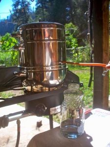 a large metal pot sitting on top of a table next to a glass filled with water