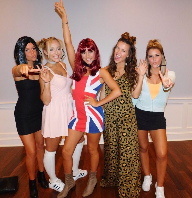 four women dressed in british style outfits posing for the camera with their arms up and thumbs up