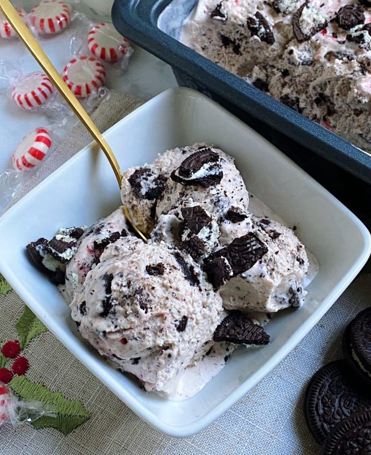 ice cream and cookies in a bowl on a table with candy canes around it