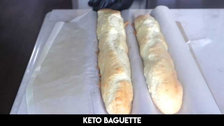 two long loafs of bread sitting on top of a cutting board next to each other