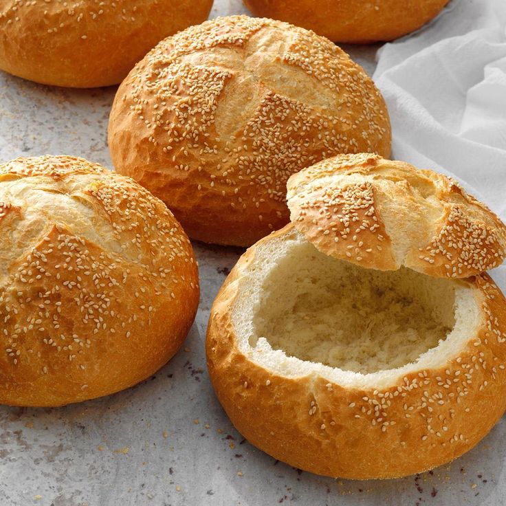 four loaves of bread sitting on top of a piece of parchment paper next to each other