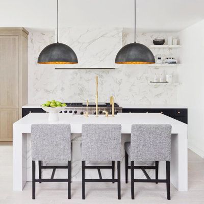 a kitchen with white counter tops and gray chairs