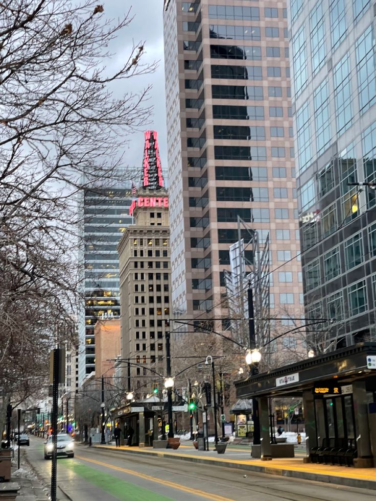 an empty city street with tall buildings in the background