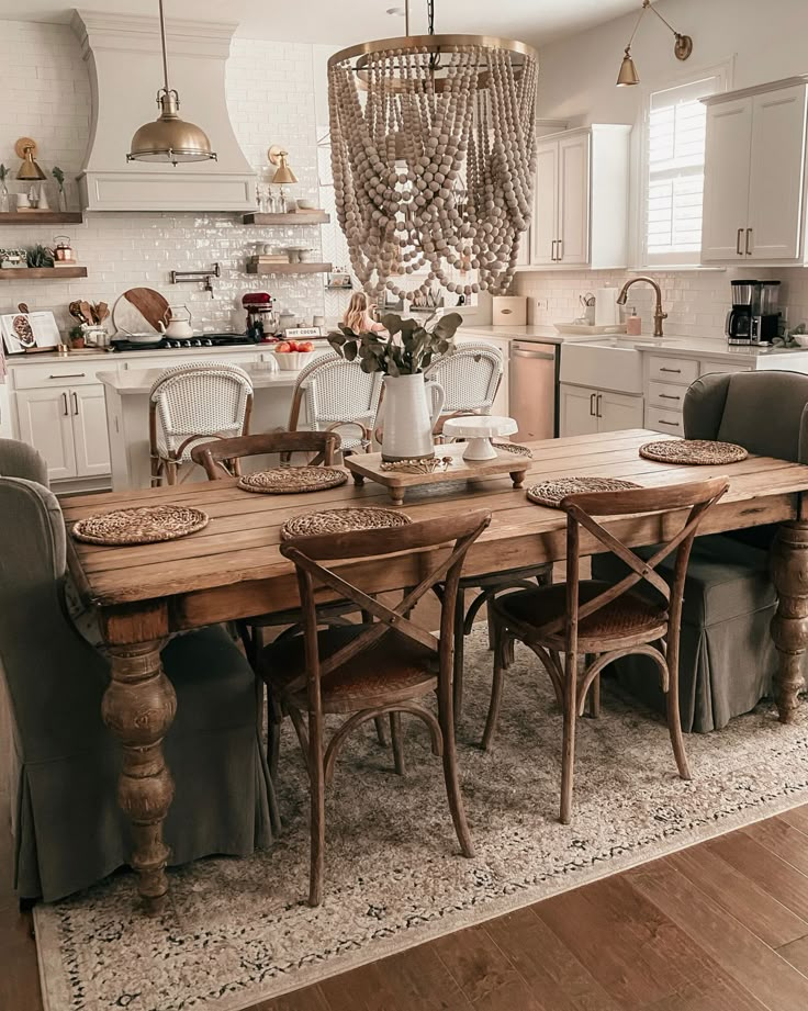 a dining room table with chairs and a chandelier hanging from the ceiling