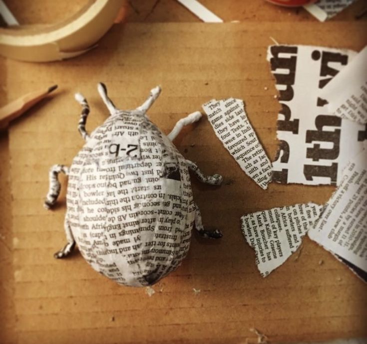 a paper mache beetle sitting on top of a wooden table