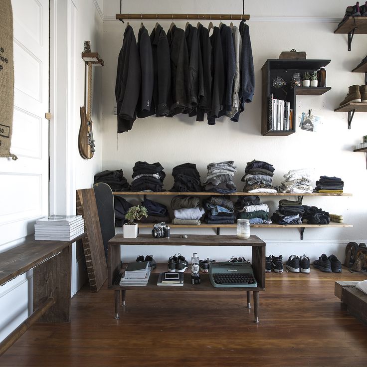 a room filled with lots of clothes and shoes on shelves next to a wooden floor