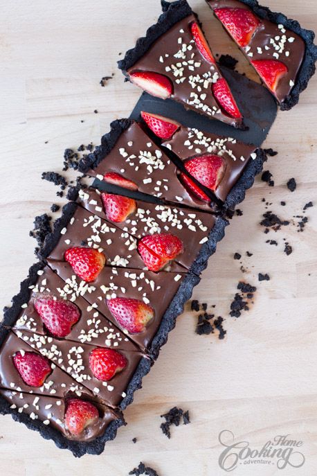 there is a slice of chocolate tart with strawberries and nuts on the top