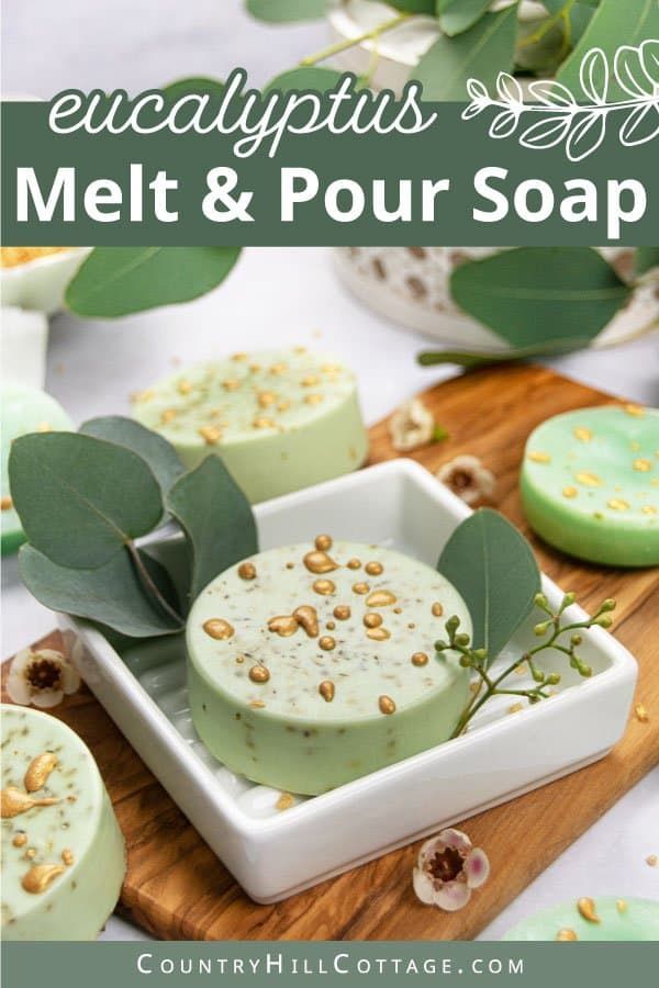 some soaps are sitting on a wooden board with green leaves and flowers in the background