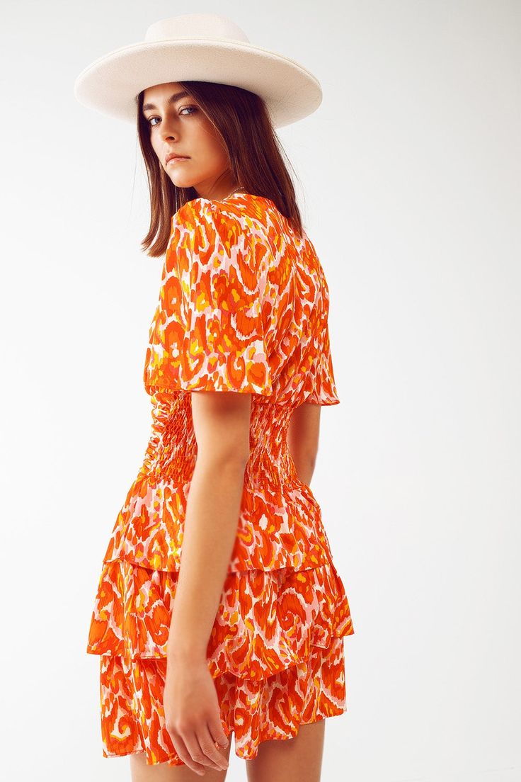 Breathe new life into your wardrobe with our Mini V Neck Dress in Floral Orange Print. Made from 100% Polyester with a 100% Polyester lining, this vibrant romantic-style dress is sure to catch eyes. The dress features a floral print design, with a V-neck neckline, short sleeves and a high waist, providing a regular fit. Our model, 5'10'' in height with measurements 31-24-35, wears a size S and the dress runs true to size. Its pleated design, tiered skirt, and cinched waist make this lightweight Perfect Fall Outfit, Dress Drape, Floral Print Design, Orange Print, Feminine Silhouette, Tier Skirt, Shades Of Orange, Romantic Style, Tiered Skirt