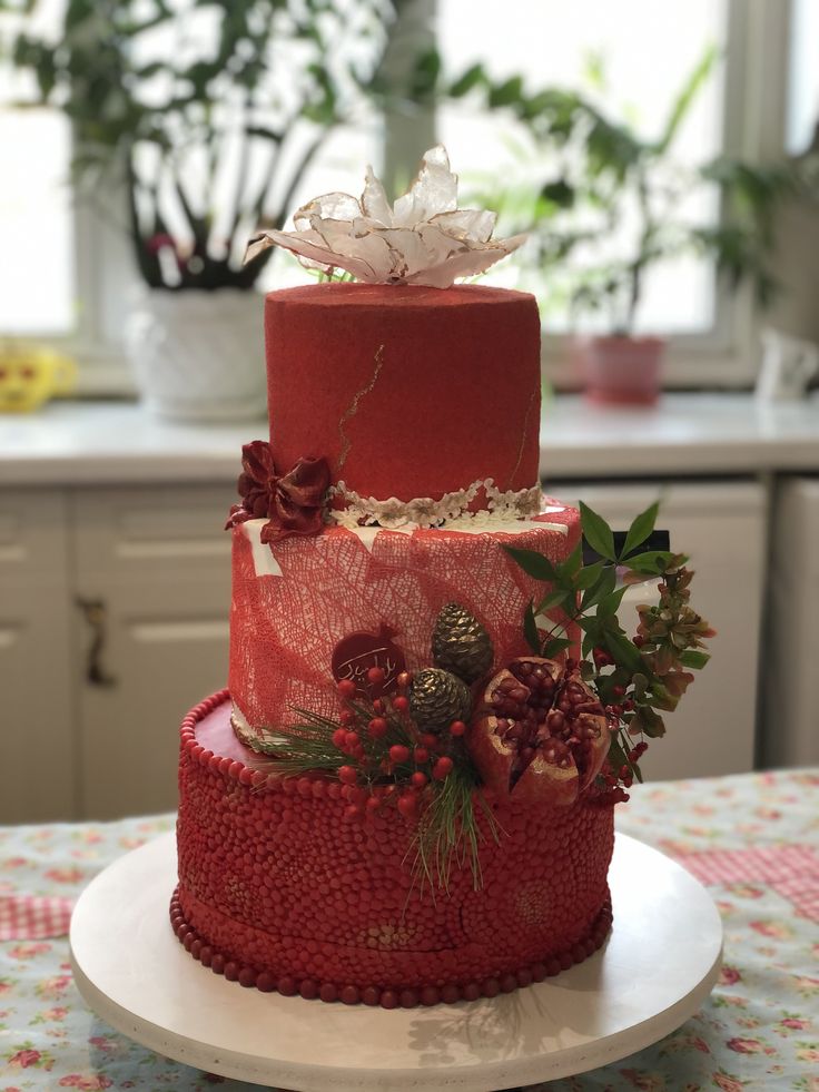 a three tiered red cake with flowers on top