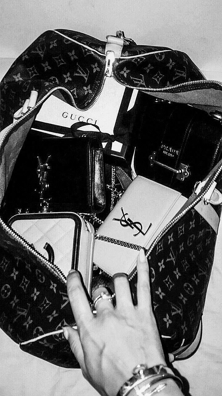 a woman's hand is holding an open louis vuitton bag