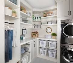 a washer and dryer in a white laundry room with open shelving on the wall