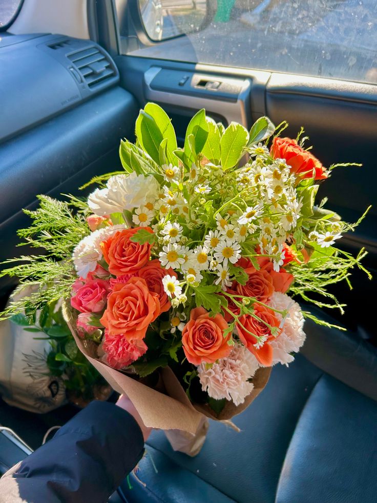 a bouquet of flowers sitting in the passenger seat of a car