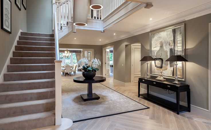 a living room filled with furniture and a stair case next to a table on top of a hard wood floor