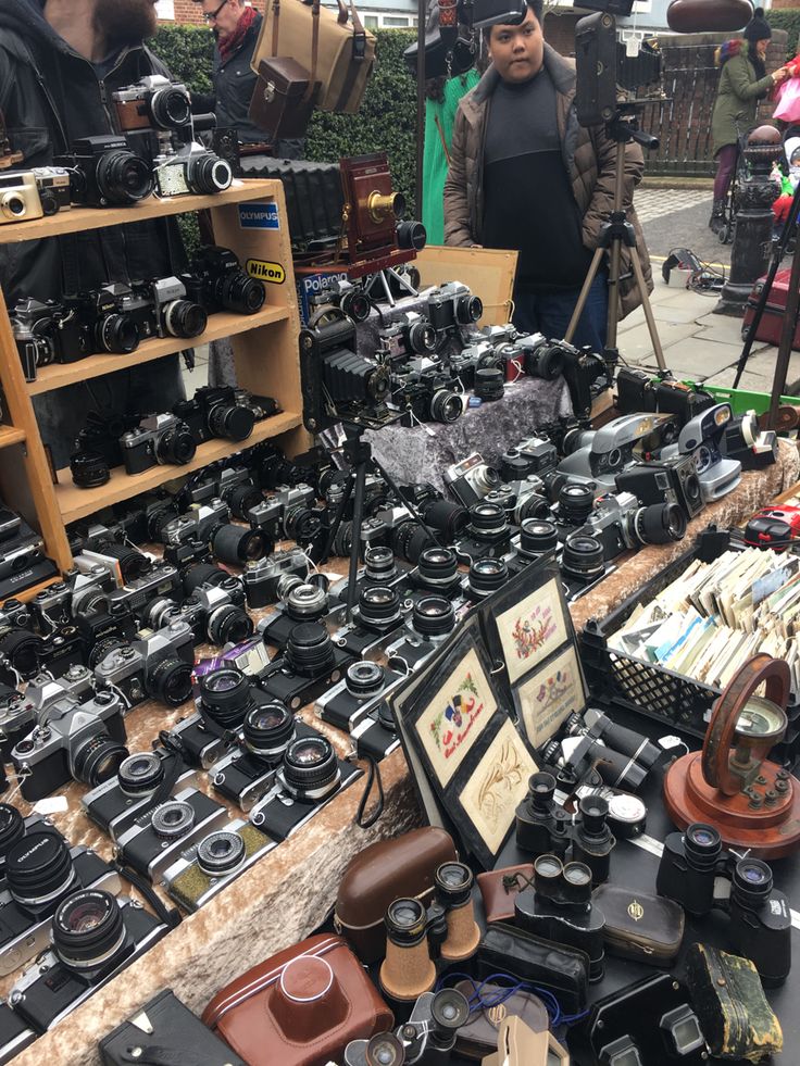 many different types of cameras on display at an outdoor market