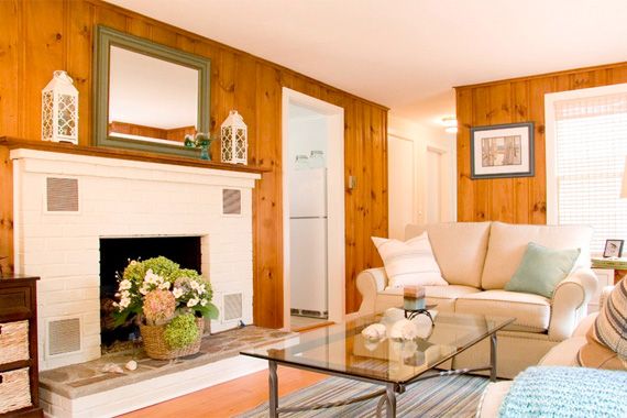 a living room filled with furniture and a fire place in front of a mirror on the wall