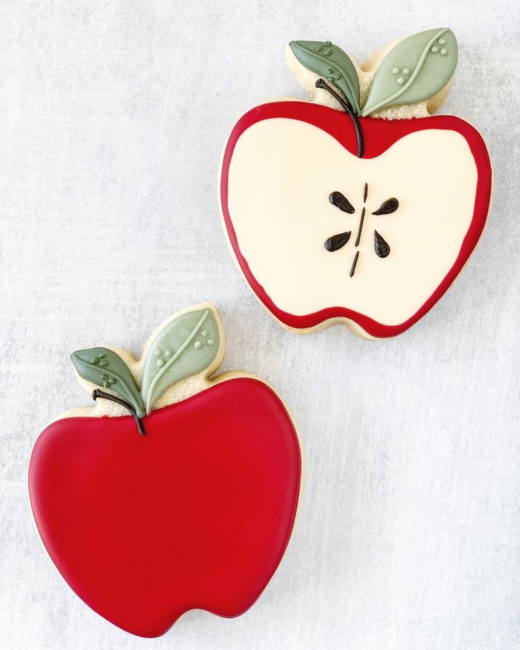 two cookies shaped like apples with leaves on them