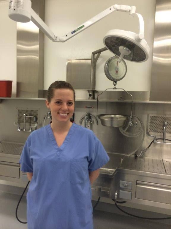 a woman in scrubs standing next to an operating room