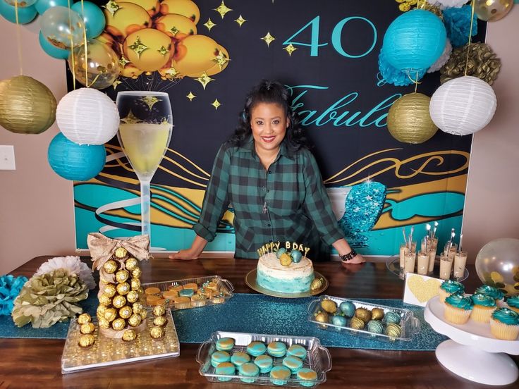 a woman standing in front of a table filled with cakes and desserts