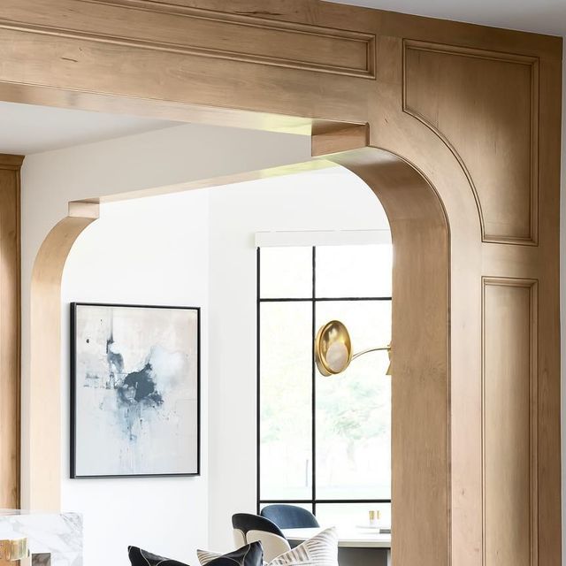 a living room filled with lots of furniture next to a wall mounted art piece on top of a wooden frame