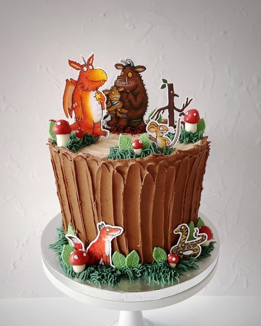 a birthday cake decorated with animals and trees