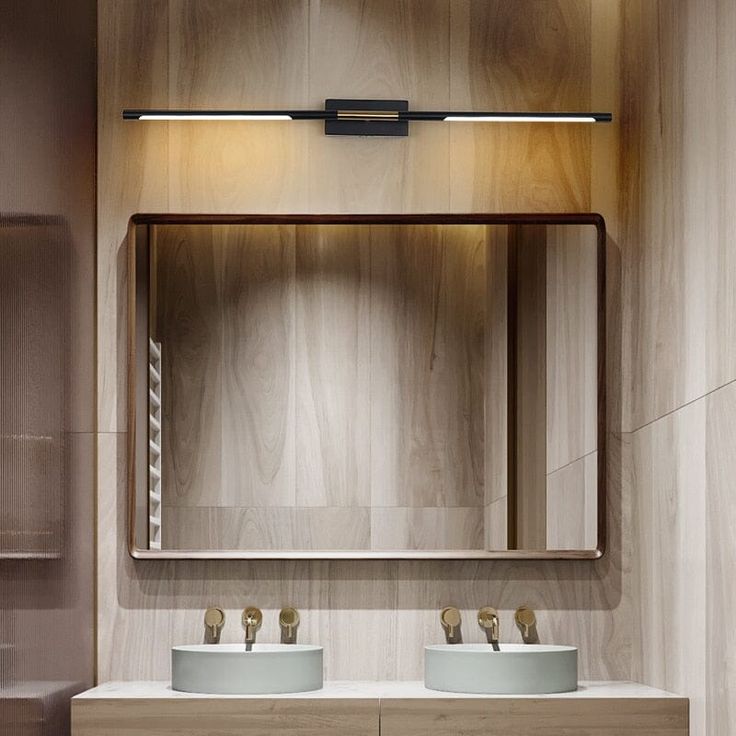 a bathroom with two sinks and a large mirror above the sink is illuminated by lights